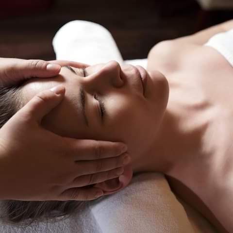 An image of a woman receiving a massage to her temples.