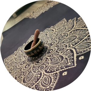 An image of a bowl sitting in the middle of a prayer rug.