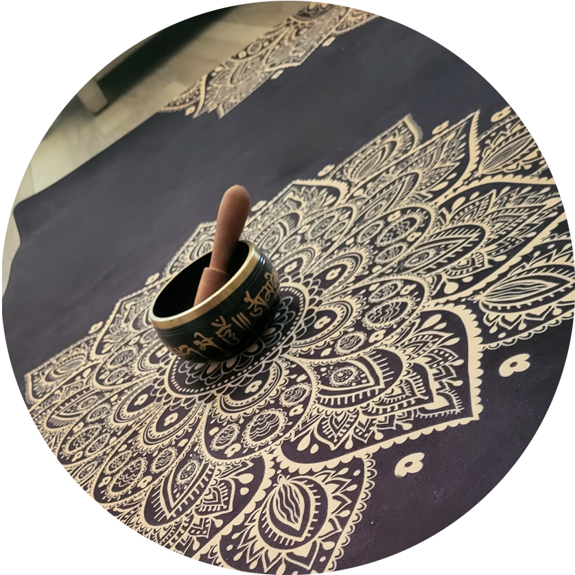 An image of a bowl sitting in the middle of a prayer rug.